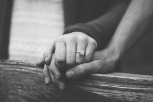 Couple holding hands with engagement ring - spousal sponsorship in Canada